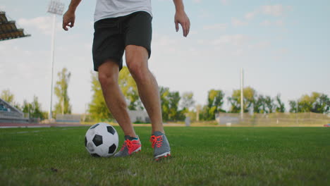 Close-up-of-a-male-soccer-player-running-with-a-soccer-ball-on-the-football-field-in-the-stadium-demonstrating-excellent-dribbling-and-ball-control.